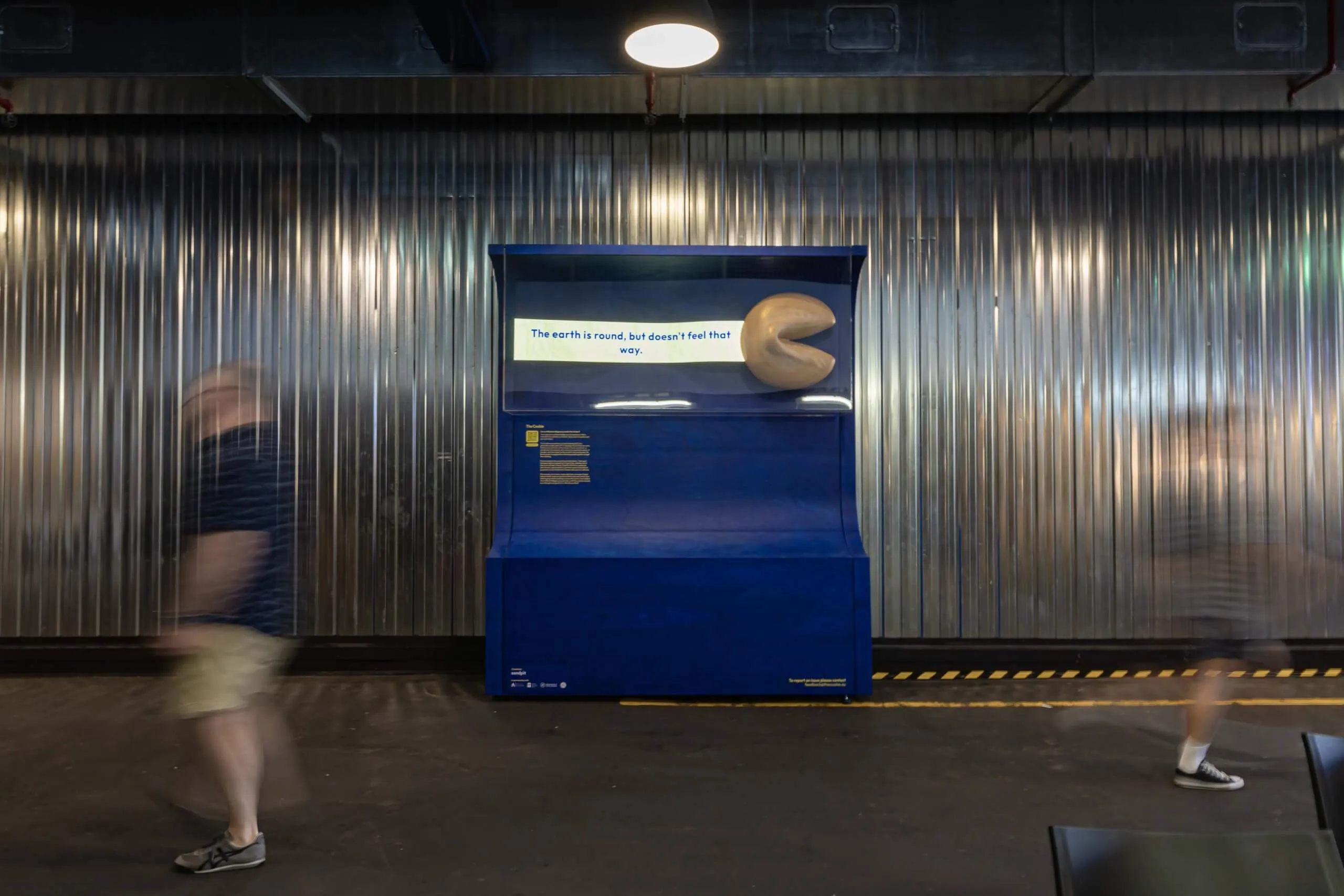 A large wooden fortune cookie installation with an LED text ticker.